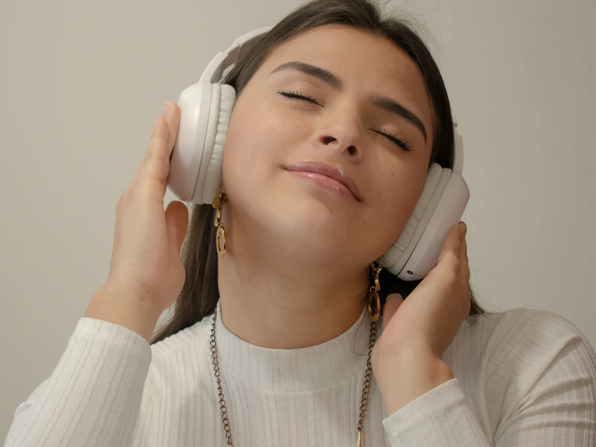 A person with eyes closed listening to a
          personalised hypnosis recording through headphones